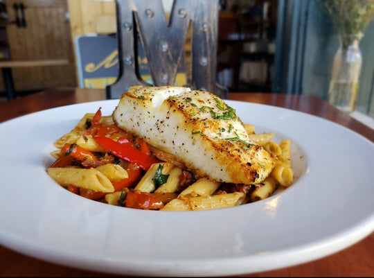 a lightly golden pan seared halibut brushed with thyme and rosemary oil. Served over penne pasta tossed with sauteed, red bell pepper, onion, and tomato. Tossed with parmesan and garlic oil. 